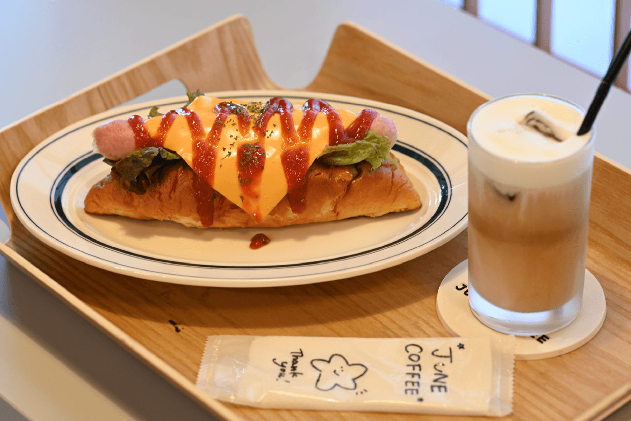 キャラメル風味の〈ジュンラテ〉とホットドッグ。（ホットドッグはなくなり次第終了）